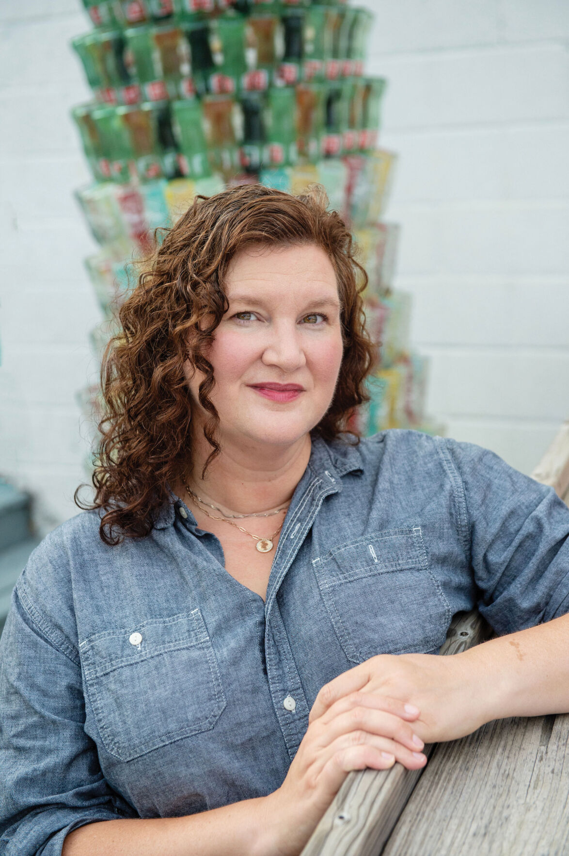 Author Amanda Uhle seated, smiling, wearing a blue shirt